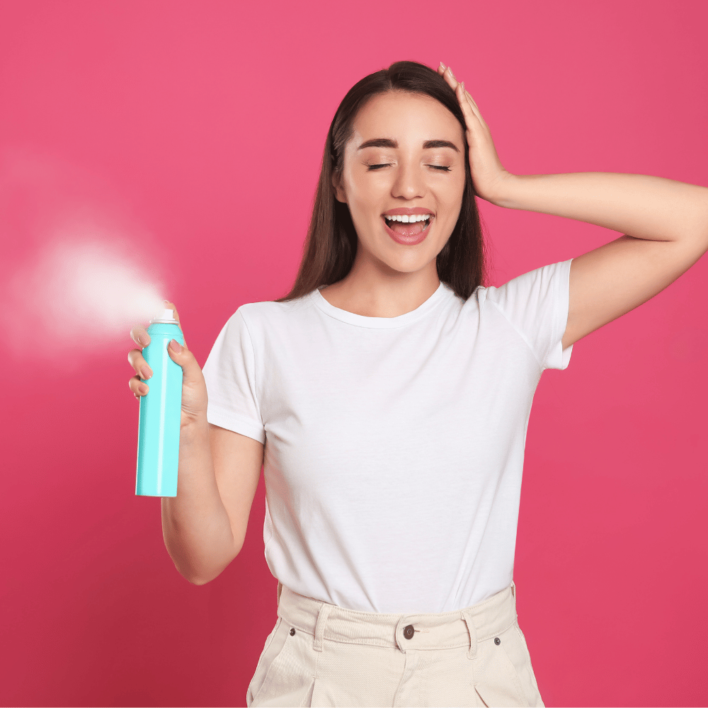 Spraying the best dry shampoo for colored hair