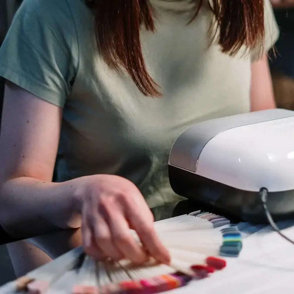 Hand using top-rated nail dryer for regular polish