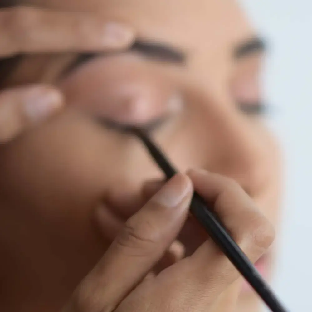 A makeup artist holding the best long-lasting nude eyeliner