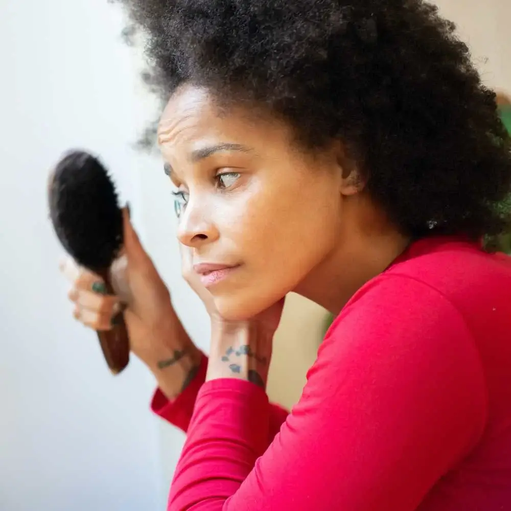 A 4C hair strand being gently detangled with a premium brush
