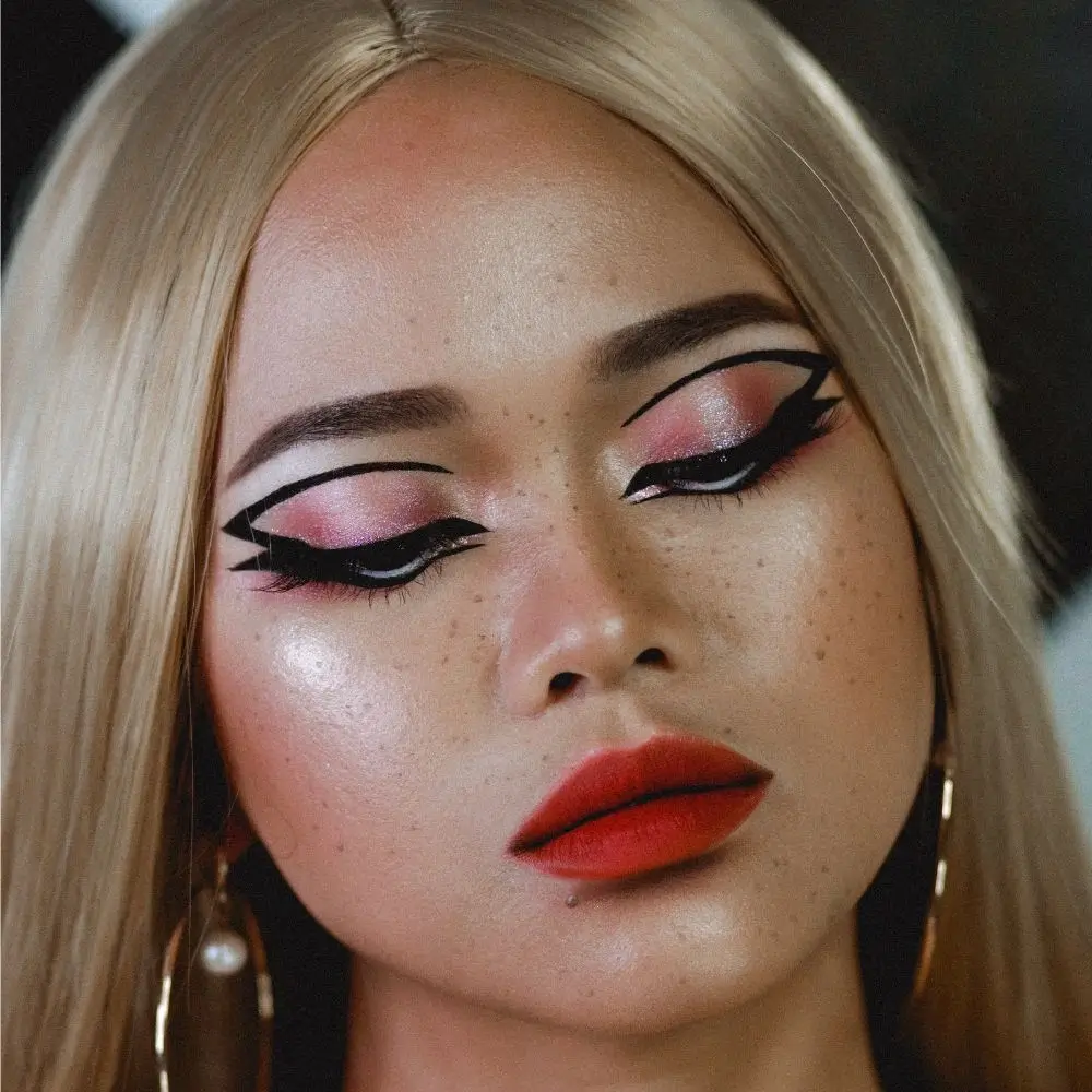 a woman wearing makeup with a unique winged and cat-eye style