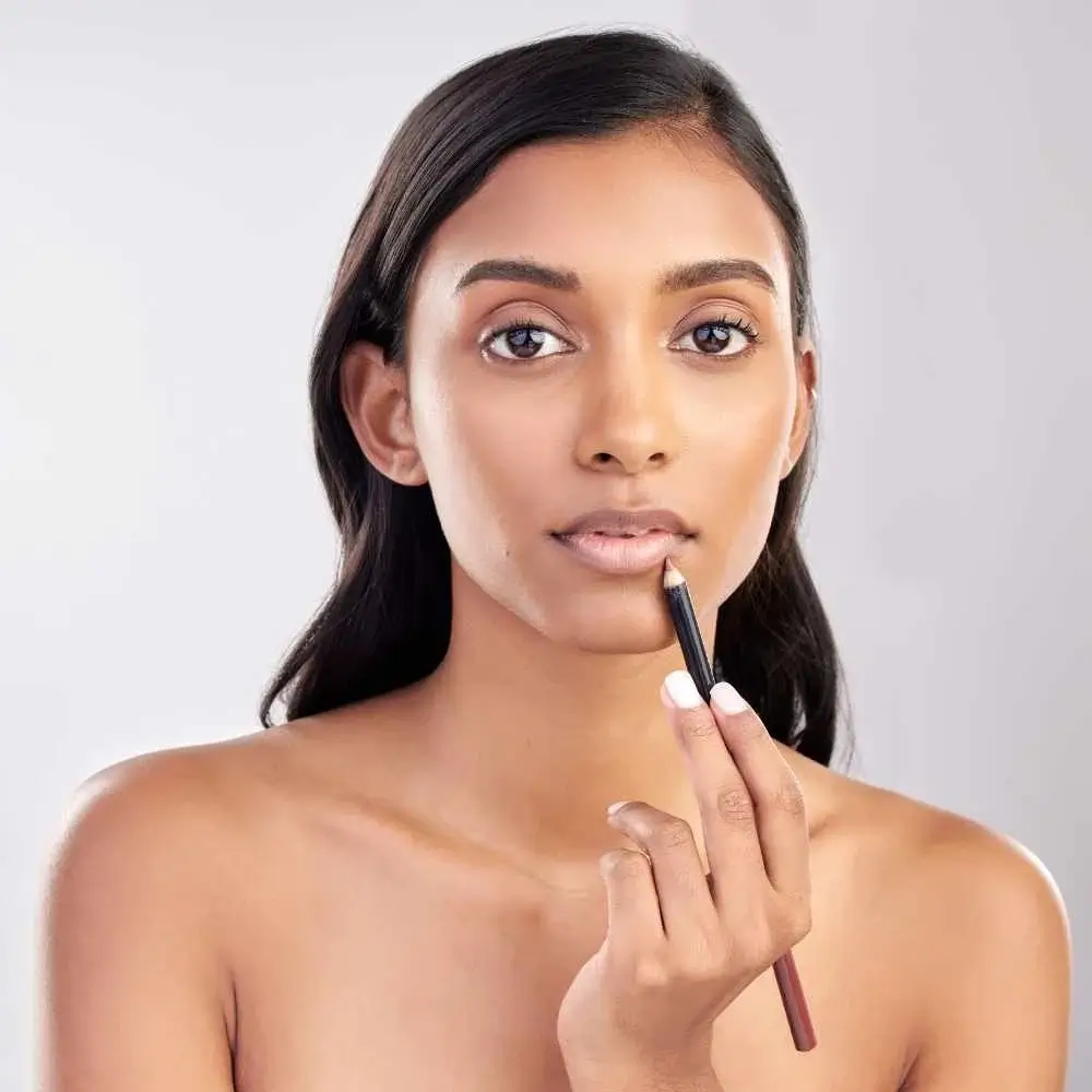 woman with bare face applying  nude lip liner