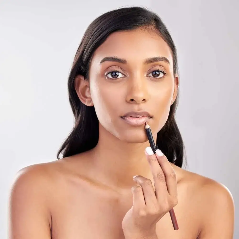 woman with bare face applying nude lip liner