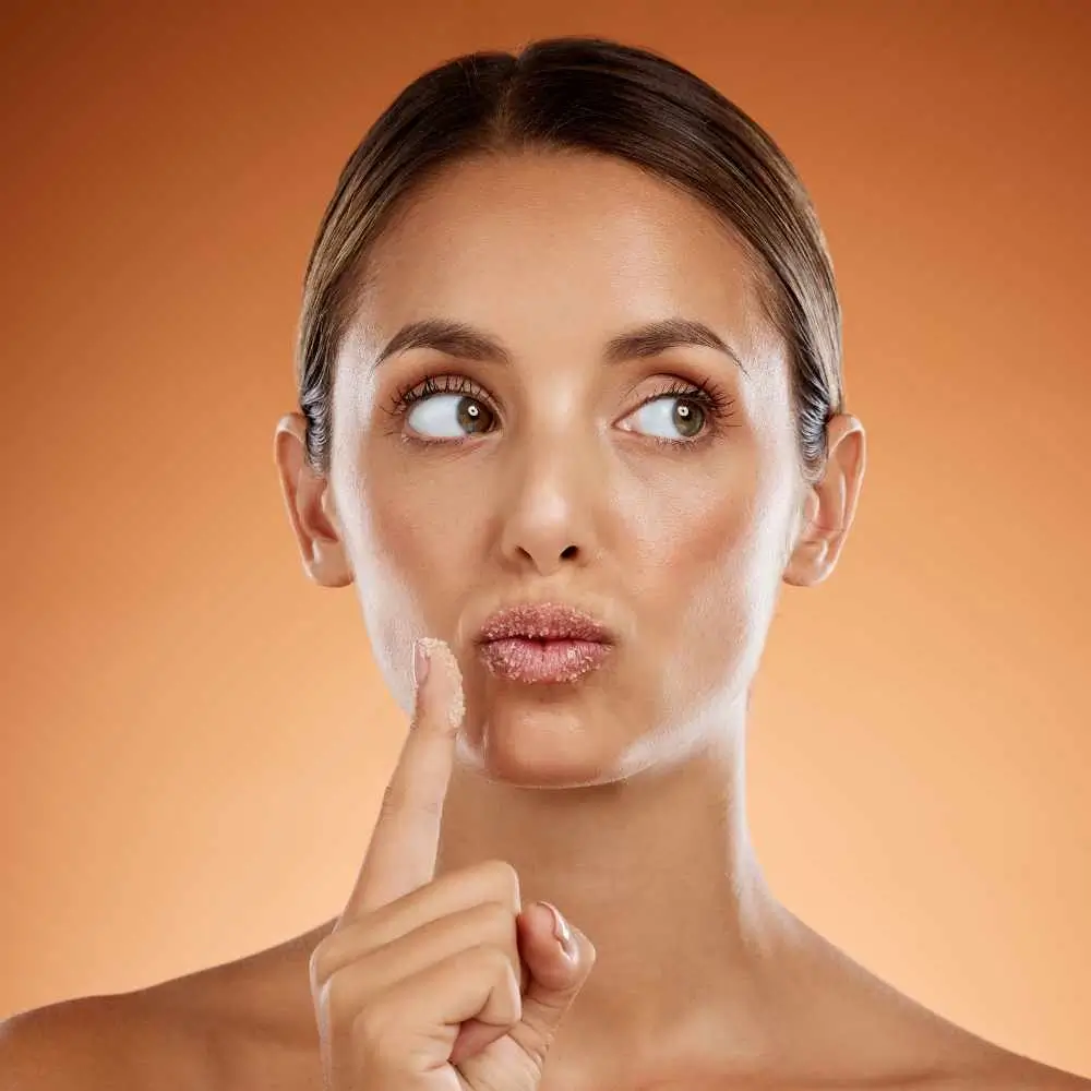 woman with lip scrub on her lips and finger