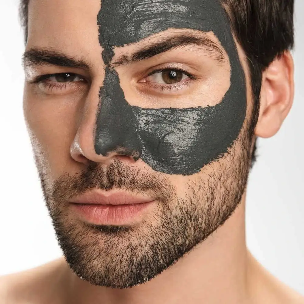 man with a clay mud face mask