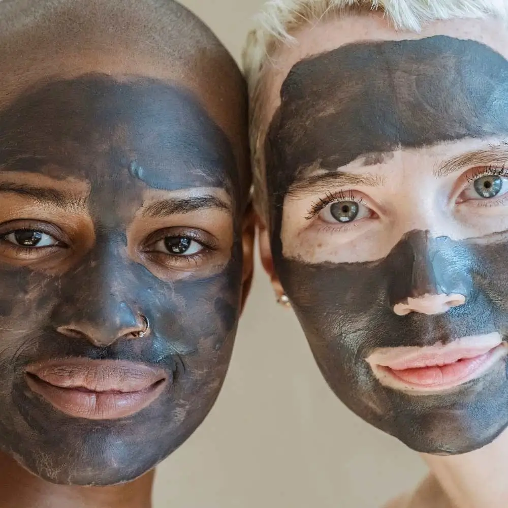 two women with clay face masks on their faces