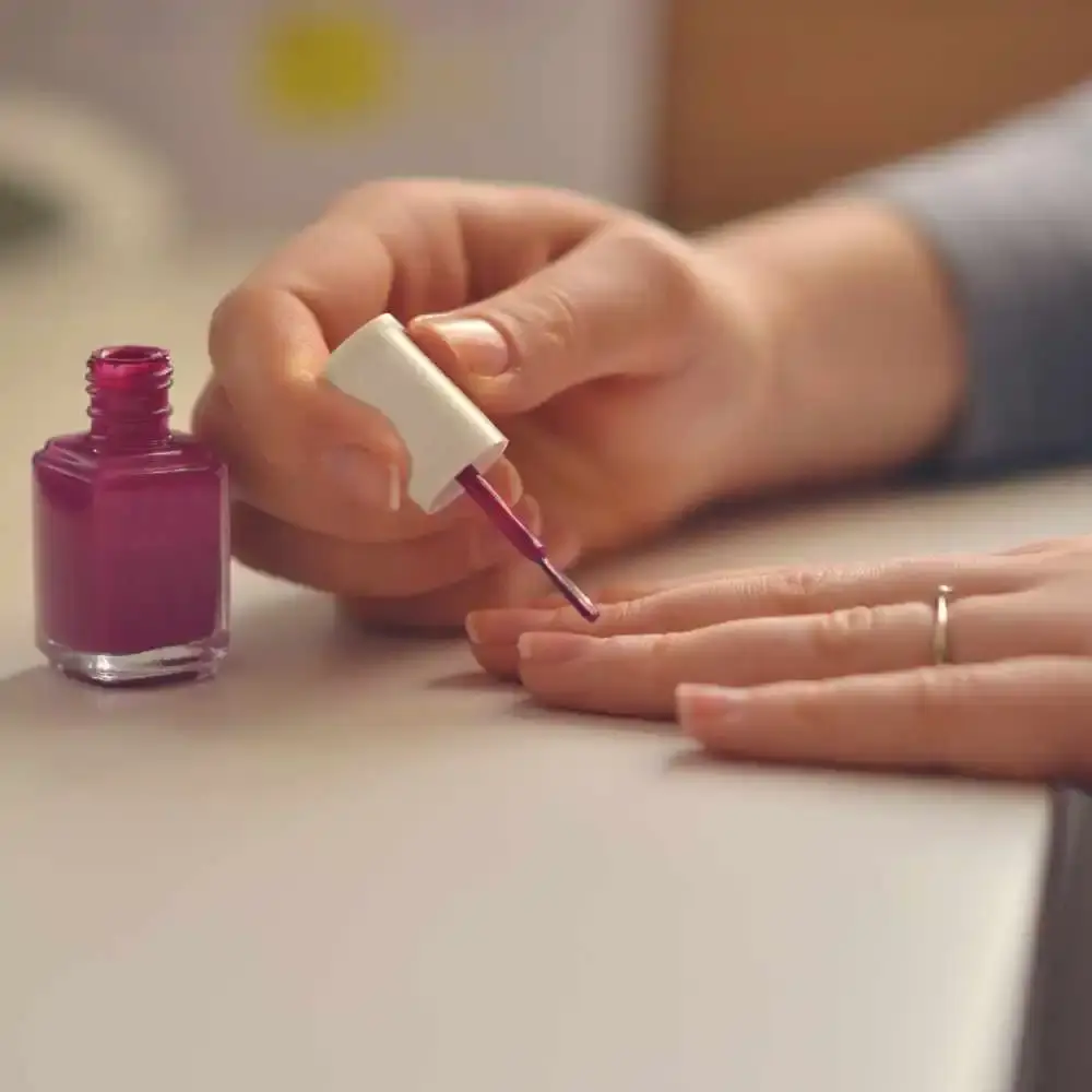 applying fuchsia nail polish
