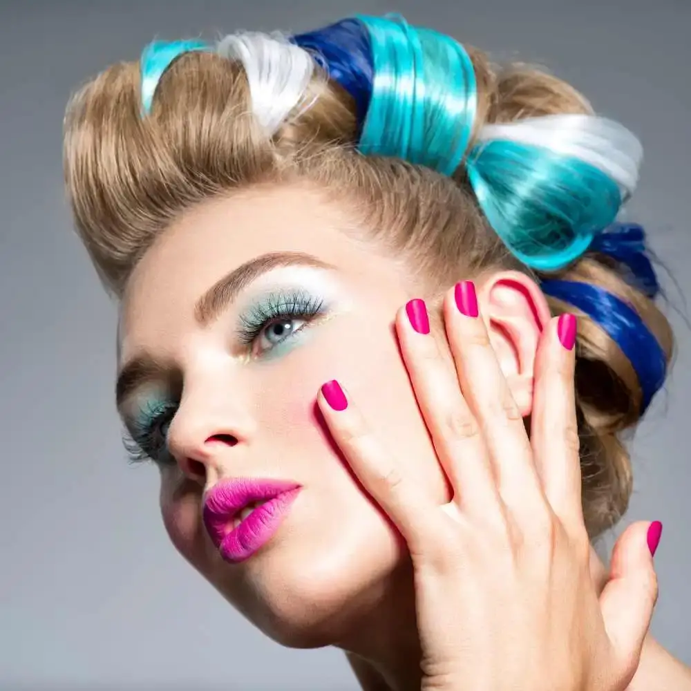 close-up shot of a beautiful woman with colored hair, makeup and bright pink nails