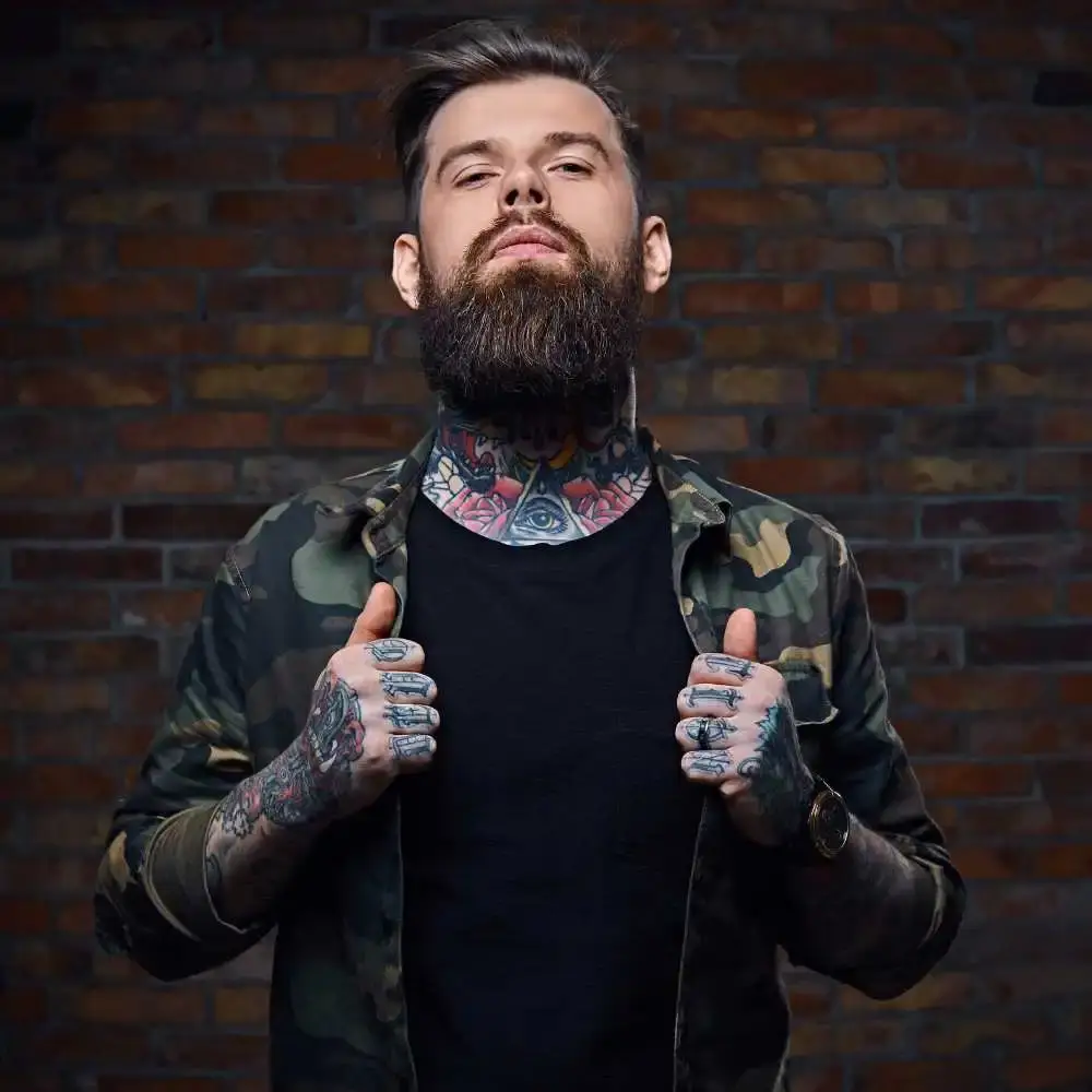 man with beard full of tattoos and wearing a jacket