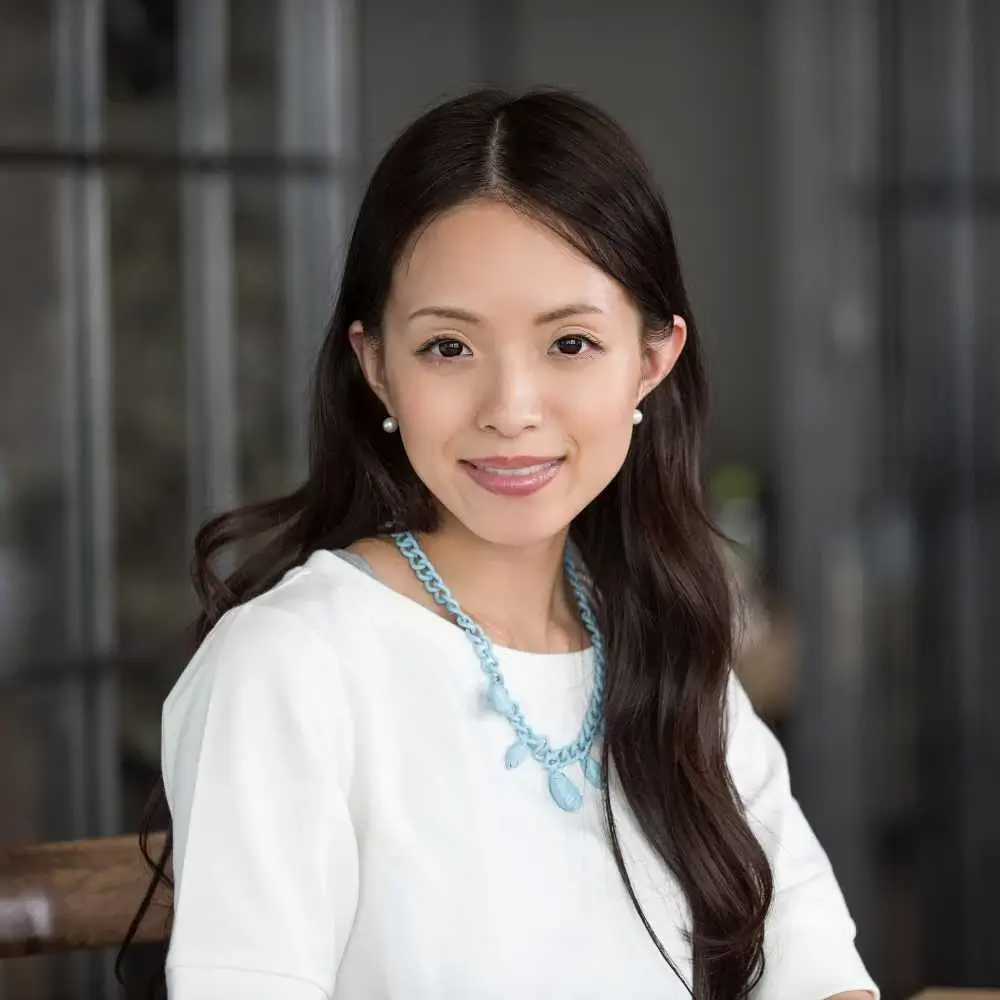 portrait of a japanese woman smiling wearing a light blue necklace