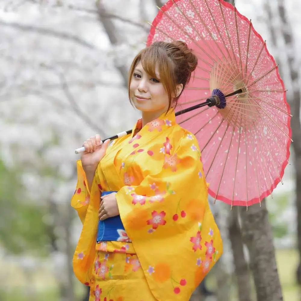 Japanese woman wearing a yellow traditional clothing and holding an umbrella