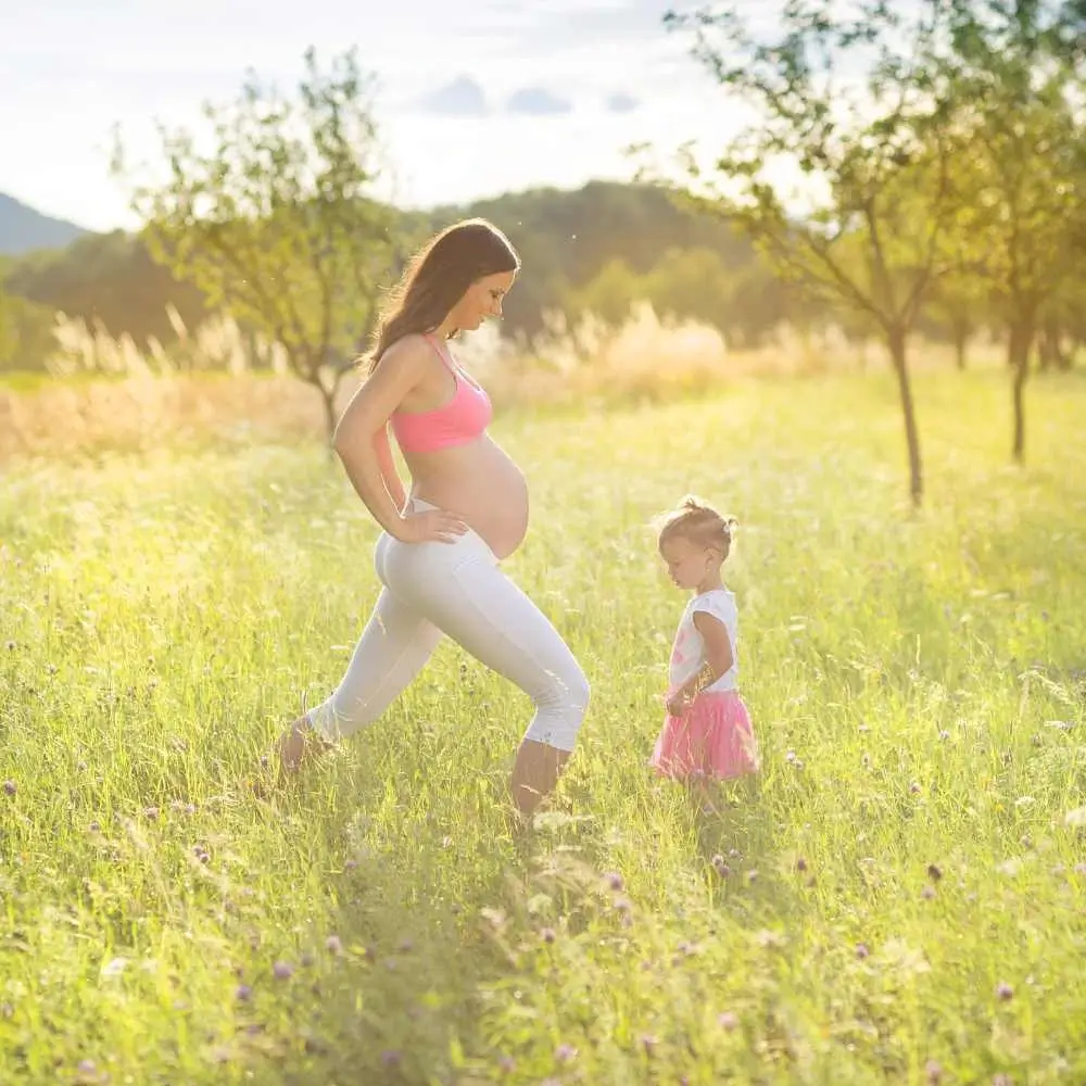 pregnant mother exercising with her little daughter