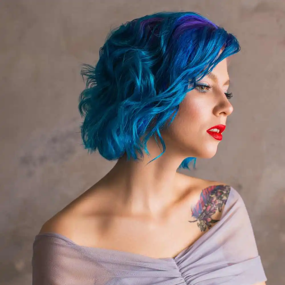 side view portrait of a woman with blue hair and red lips