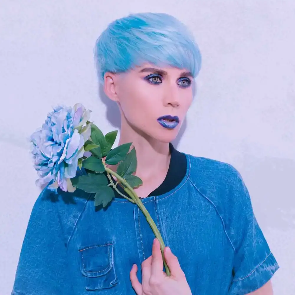 model with blue short hair and blue lipstick holding a blue flower