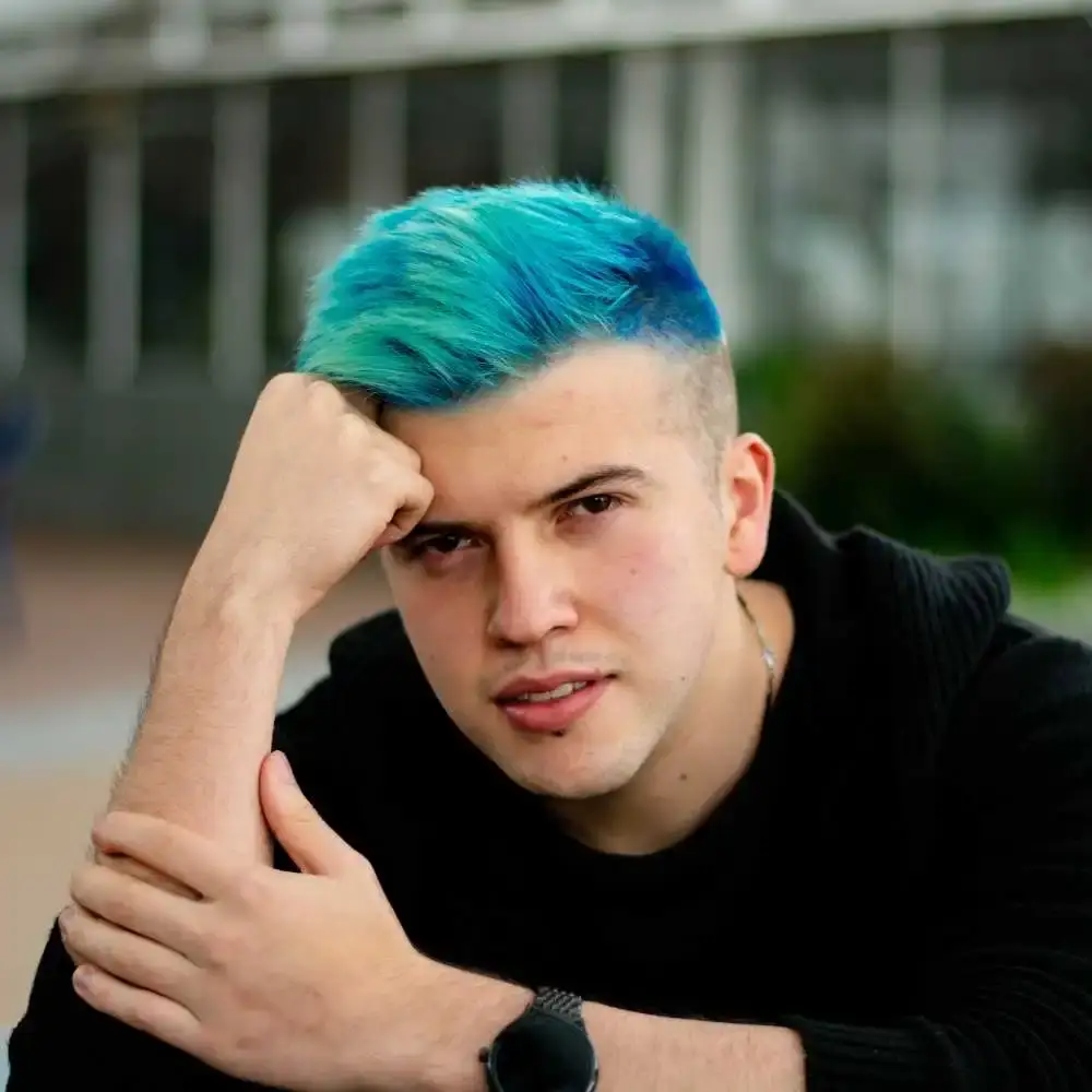 man wearing a black clothing and a black watch with blue hair