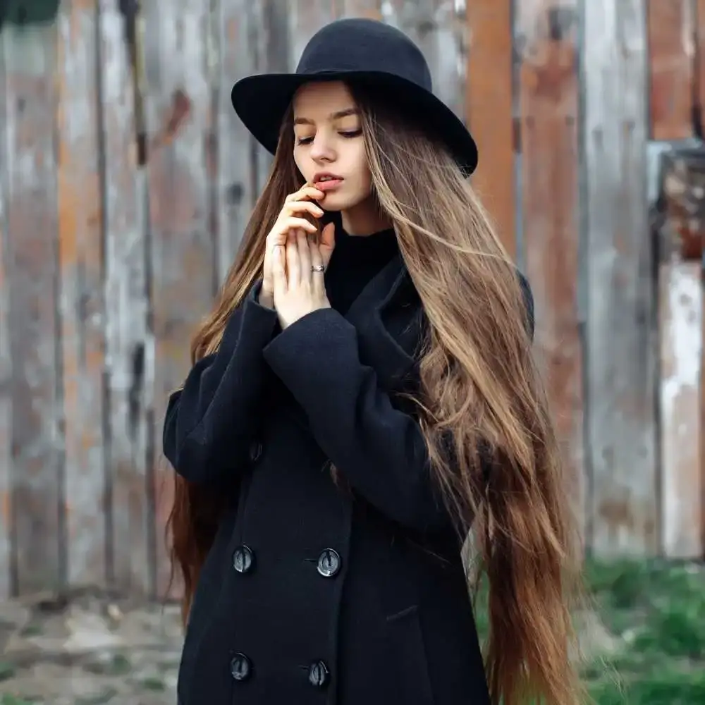 young female wearing a black hat with very long brown hair