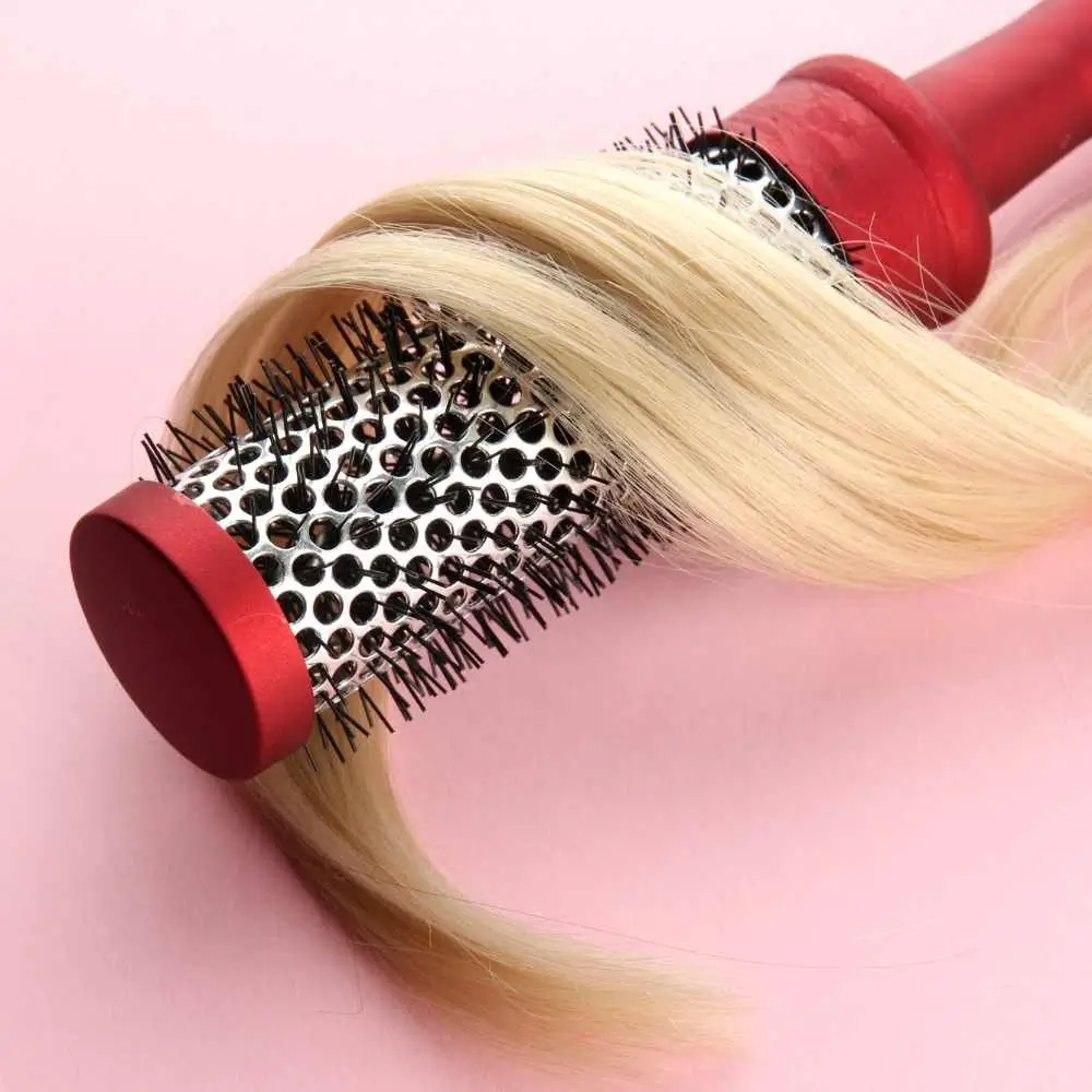 red curling brush with blonde hair