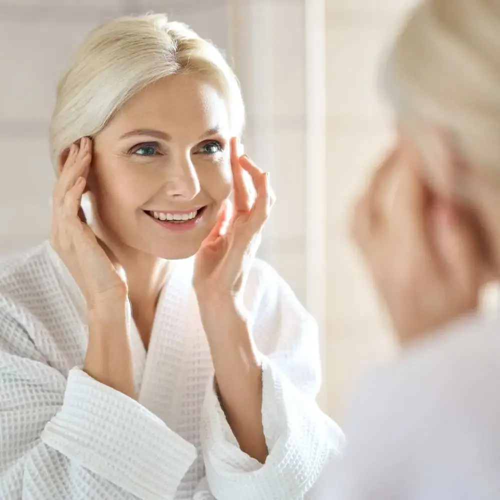 Woman's reflection in mirror showcasing the effect of top setting powde