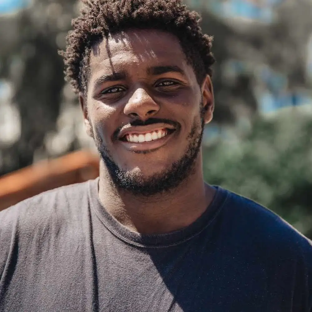 portrait of a smiling man with curly black hair