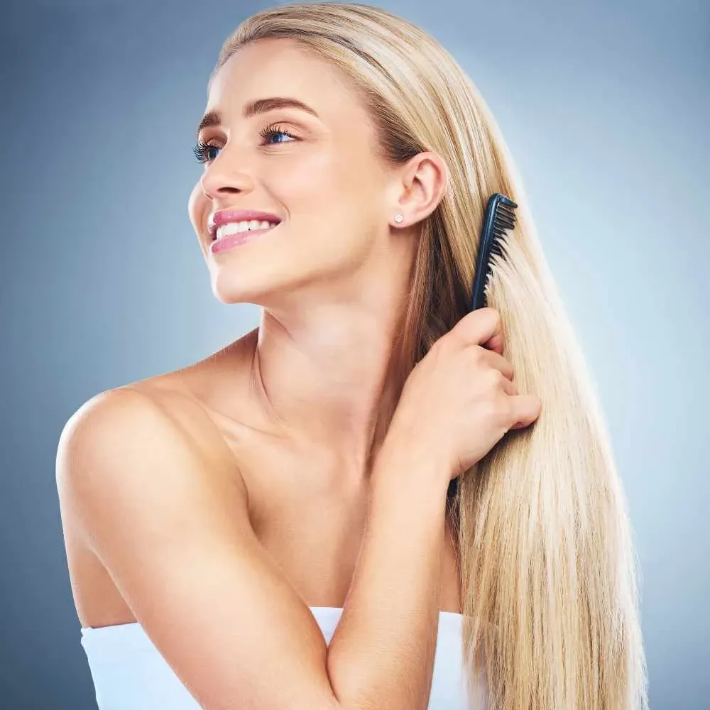 woman combing her long blonde hair