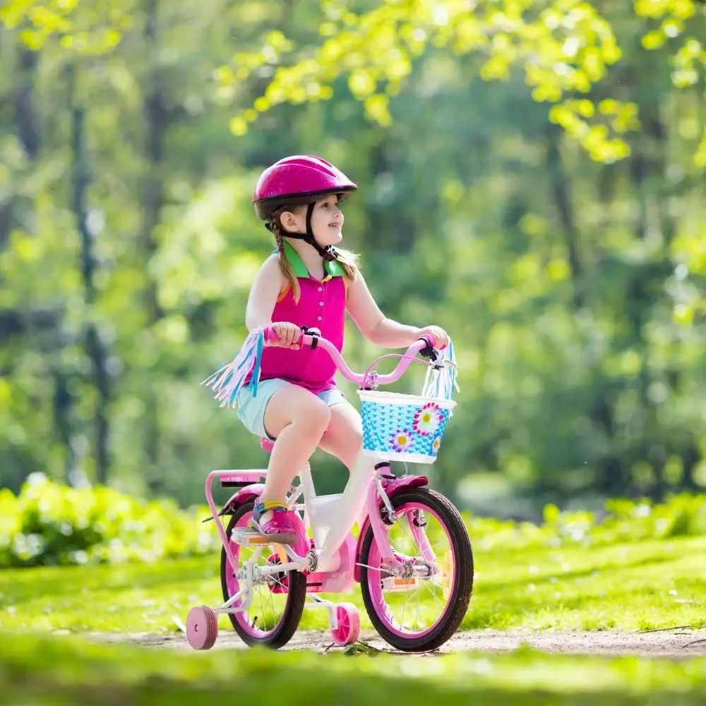 A girl riding a pink bike