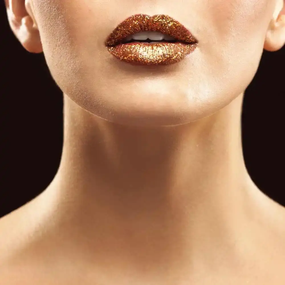 closeup of a woman's lips in glittery gold lipstick