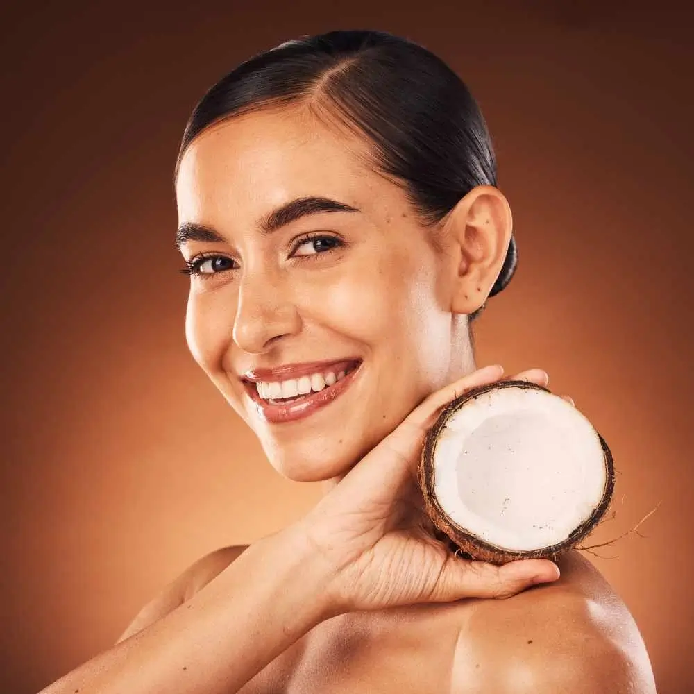 smiling woman holding a fresh and opened coconut