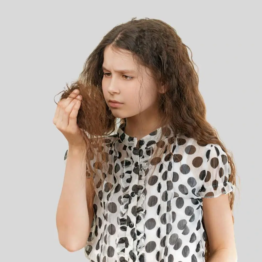 a girl wearing black polka dots blouse with frizzy curly hair