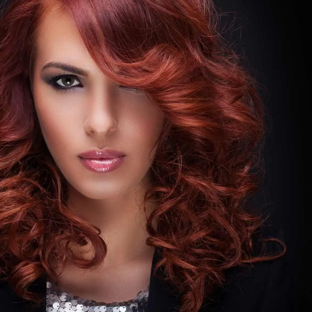 portrait of a woman with makeup and red curled hair