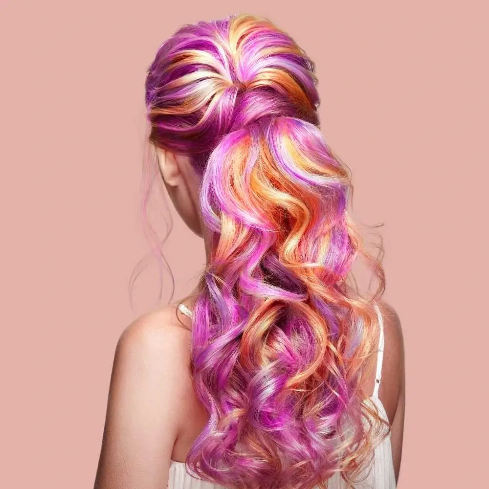 back view of a young woman's head with colorful curly hair