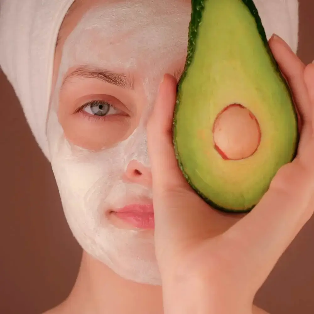 woman wearing face mask and holding avocado