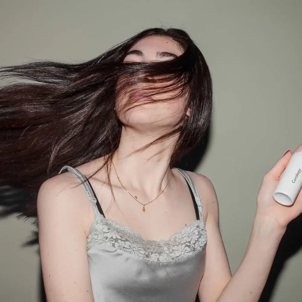 woman holding hair conditioner bottle