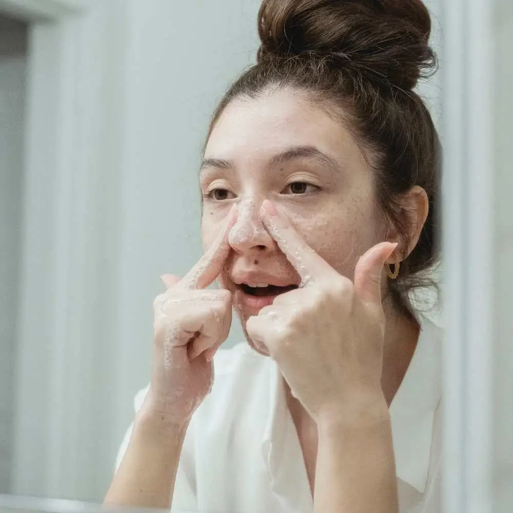 washing face using facial wash for black heads