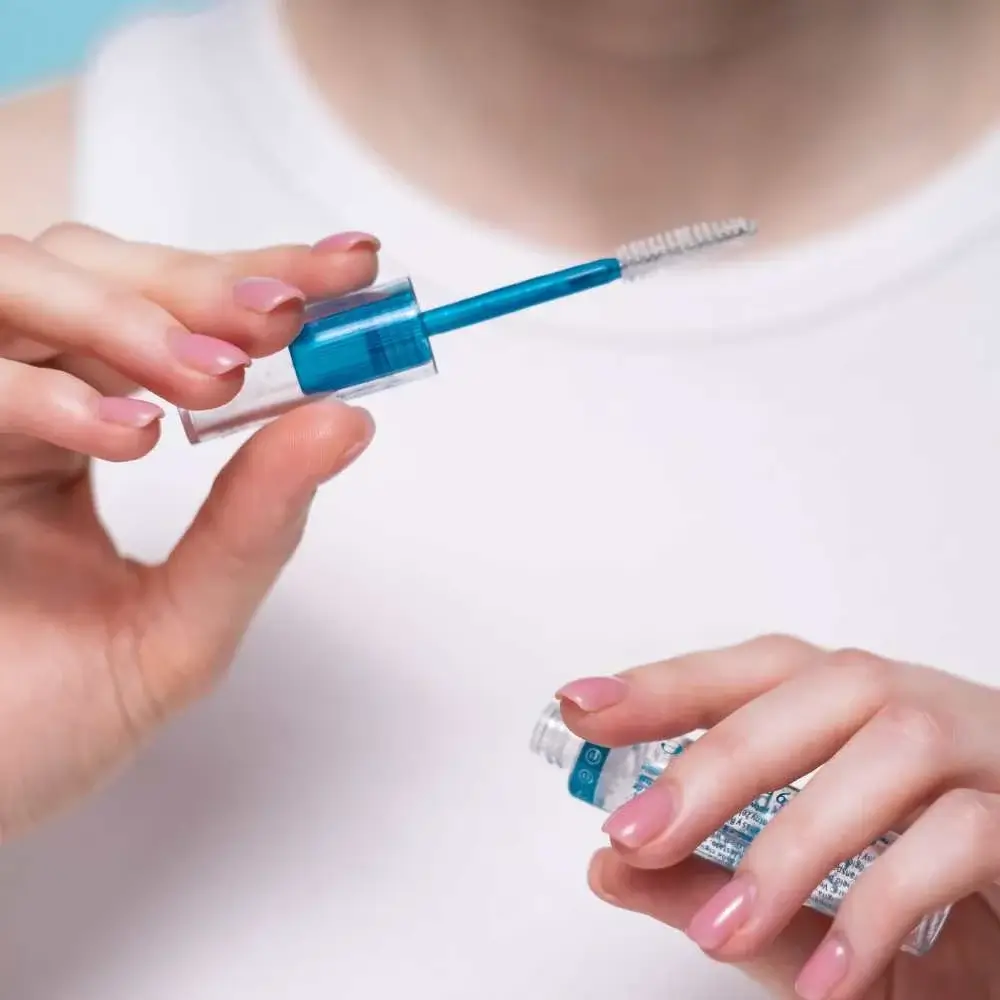 Close-up view of a clear eyebrow gel tube and brush