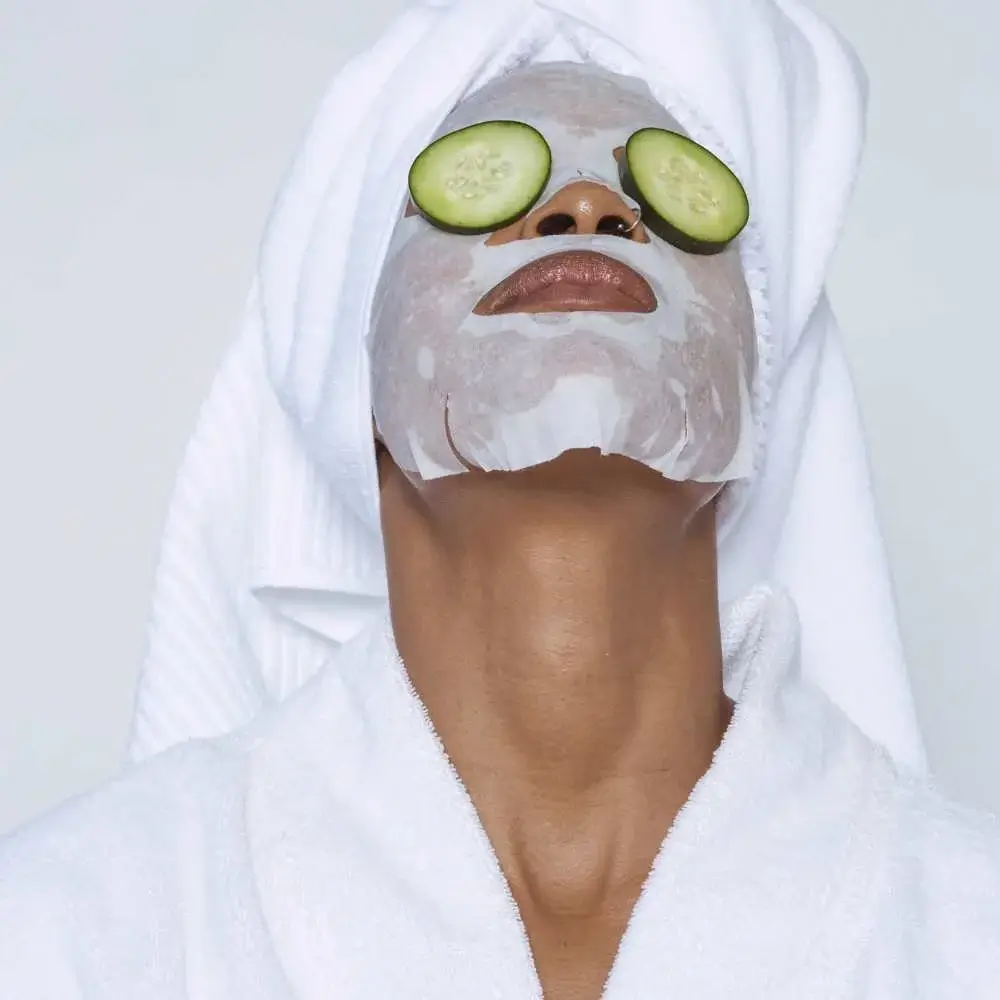wearing sheet mask with cucumber on eyes