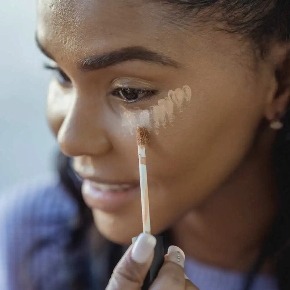 applying concealer on under eye