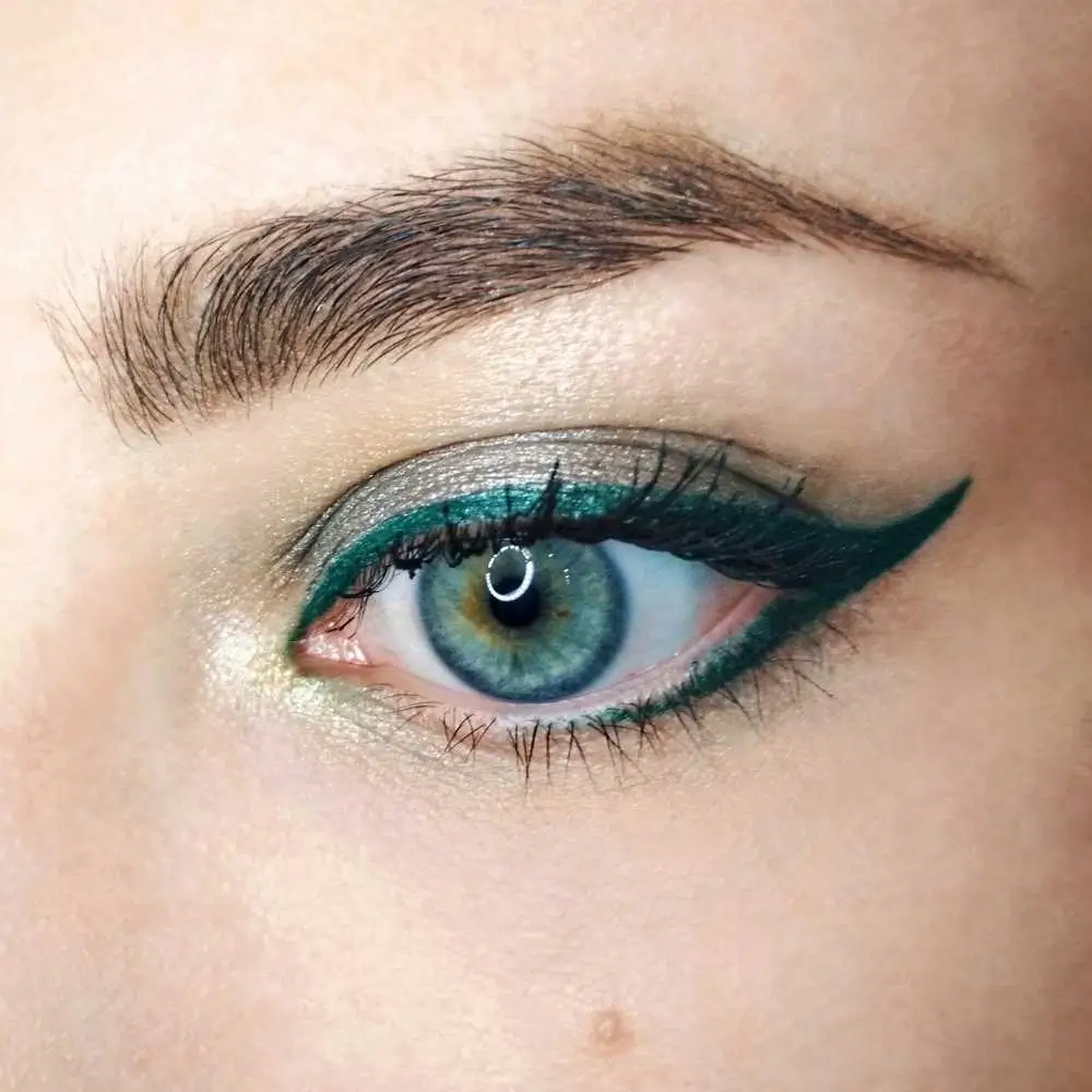 closeup of an eye with green glitter eyeliner