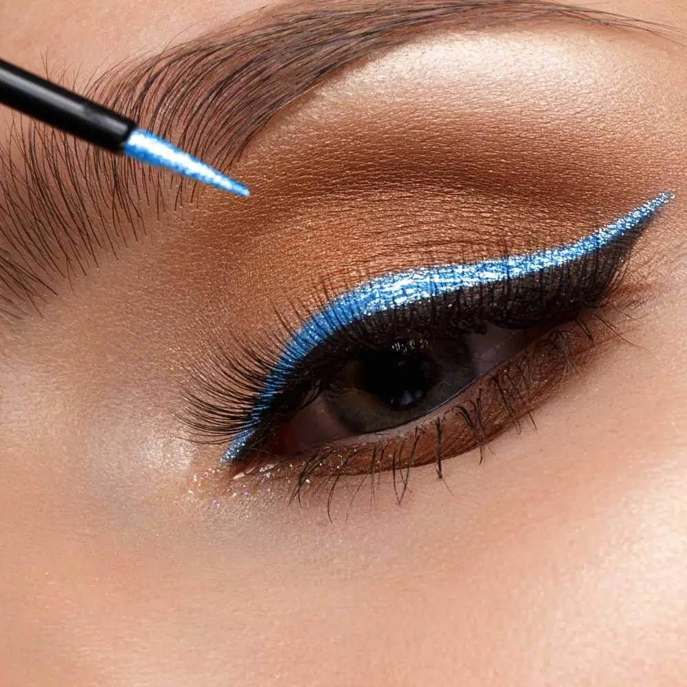 closeup of an eye with blue glitter eyeliner and brown eyeshadow