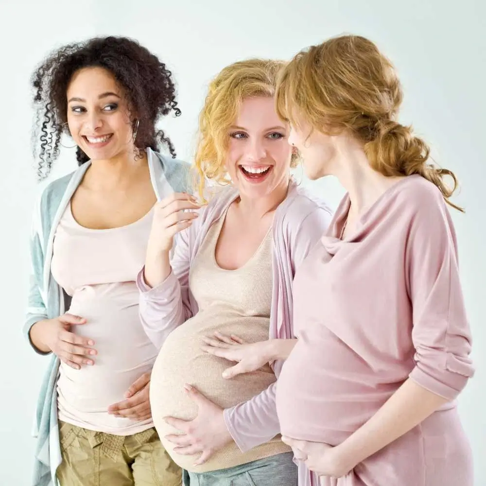 three pregnant women smiling