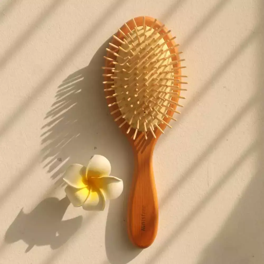 wooden hair brush and a flower