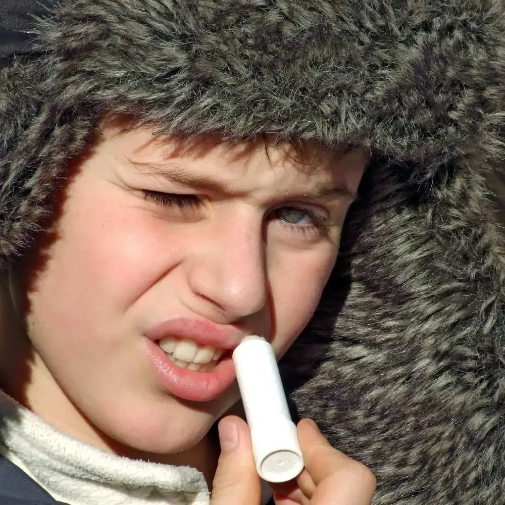 Man confidently applying lip balm, maintaining his lip health