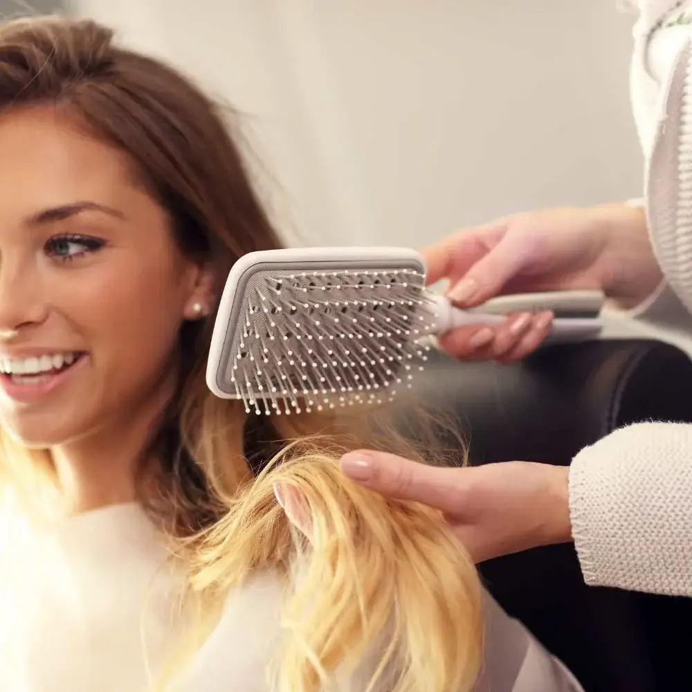Person gently brushing fine hair to avoid damage