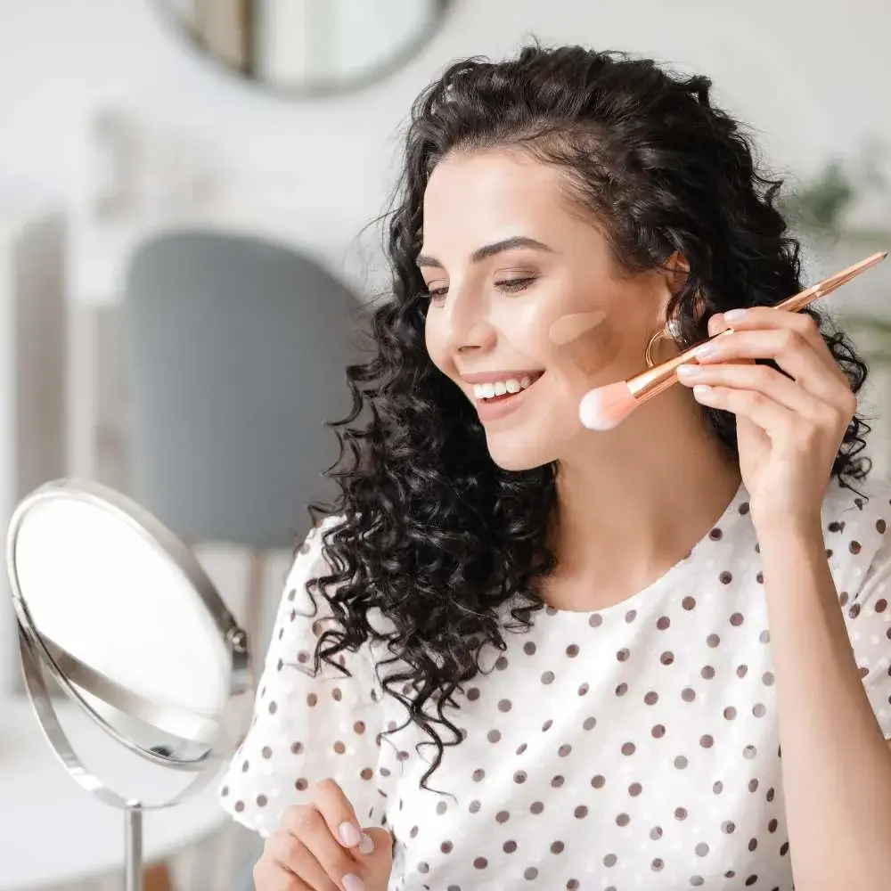 applying drugstore contour to define her facial features