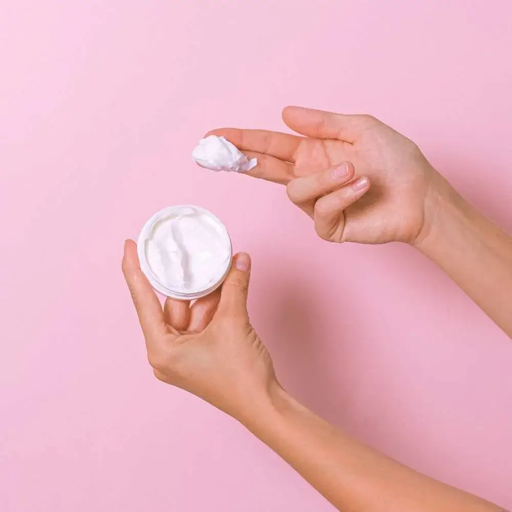 Woman's hand holding a tube of the best moisturizer for makeup