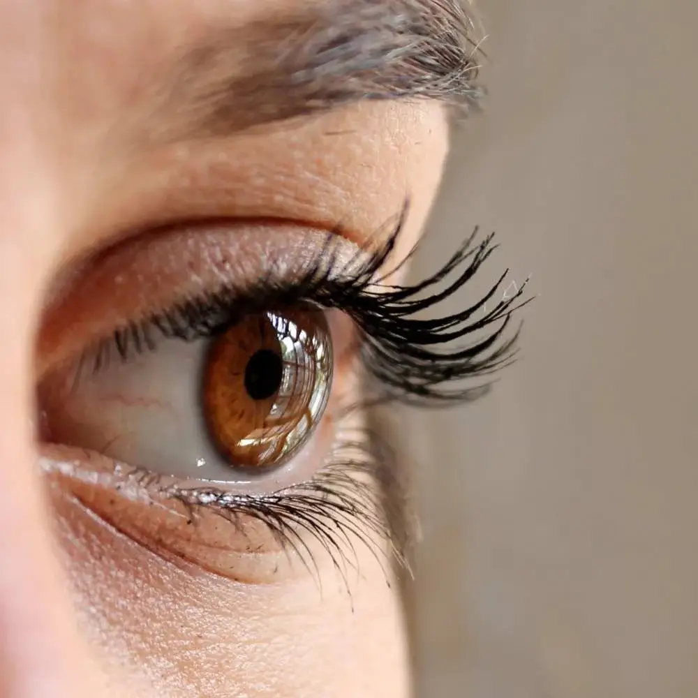 Woman with curled lashes, achieved by using a heated eyelash curler