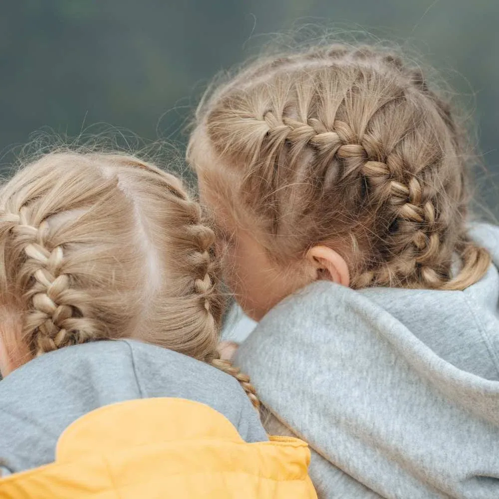 Twin girls enjoying their matching braid hairstyles