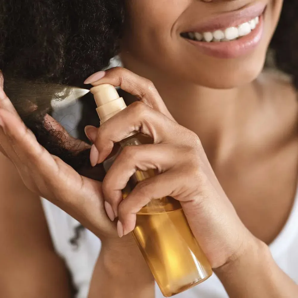 Person applying Argan Oil to their hair