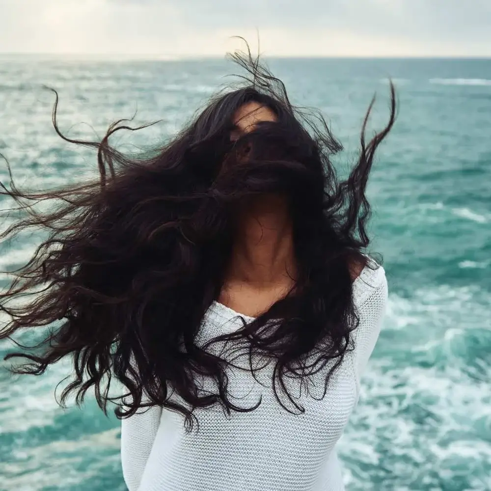 Dark-haired woman confidently displaying the results of using dry shampoo