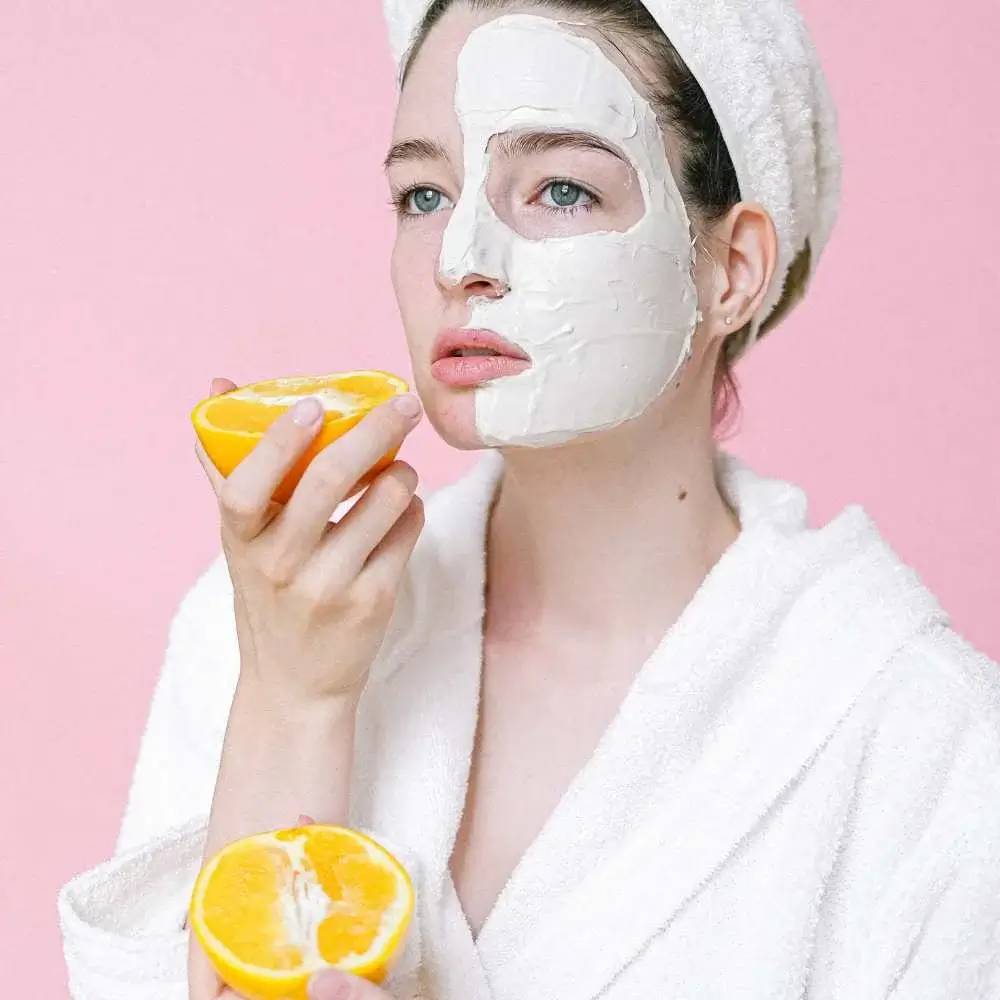 Woman applying Vitamin C cream to her face for brighter, healthier skin