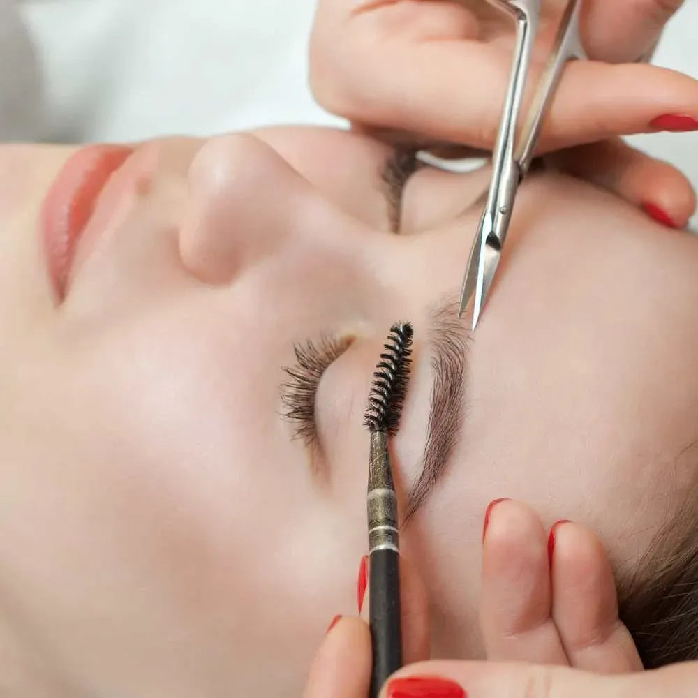 Picture of a person using curved eyebrow scissors for precision